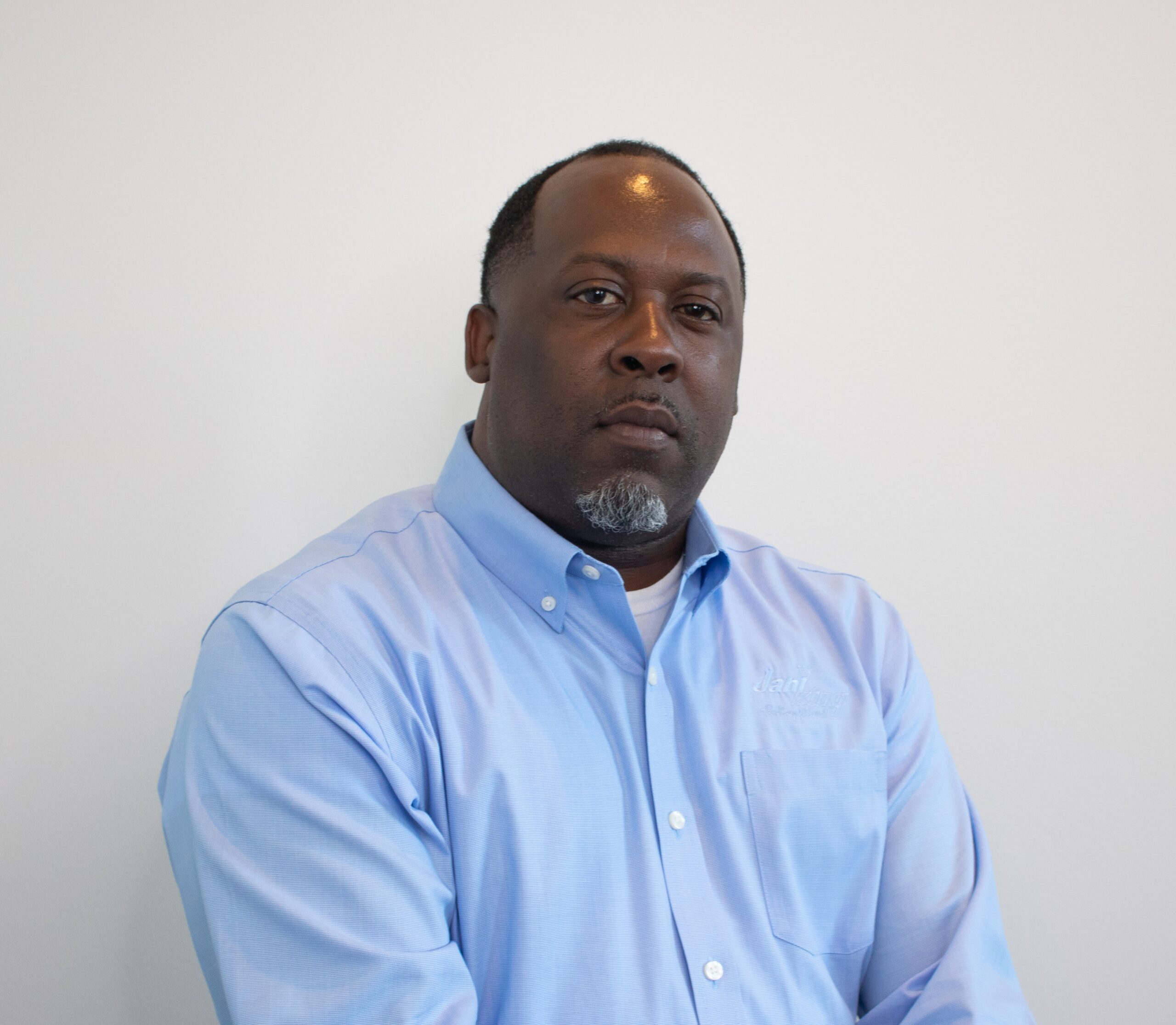 a man in a blue shirt is sitting down