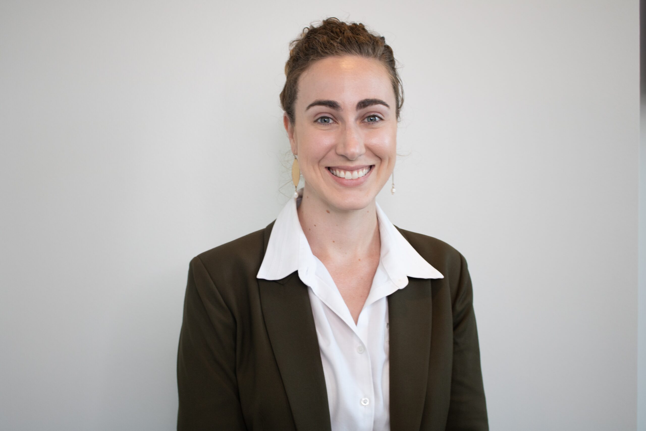 a woman in a suit smiling at the camera