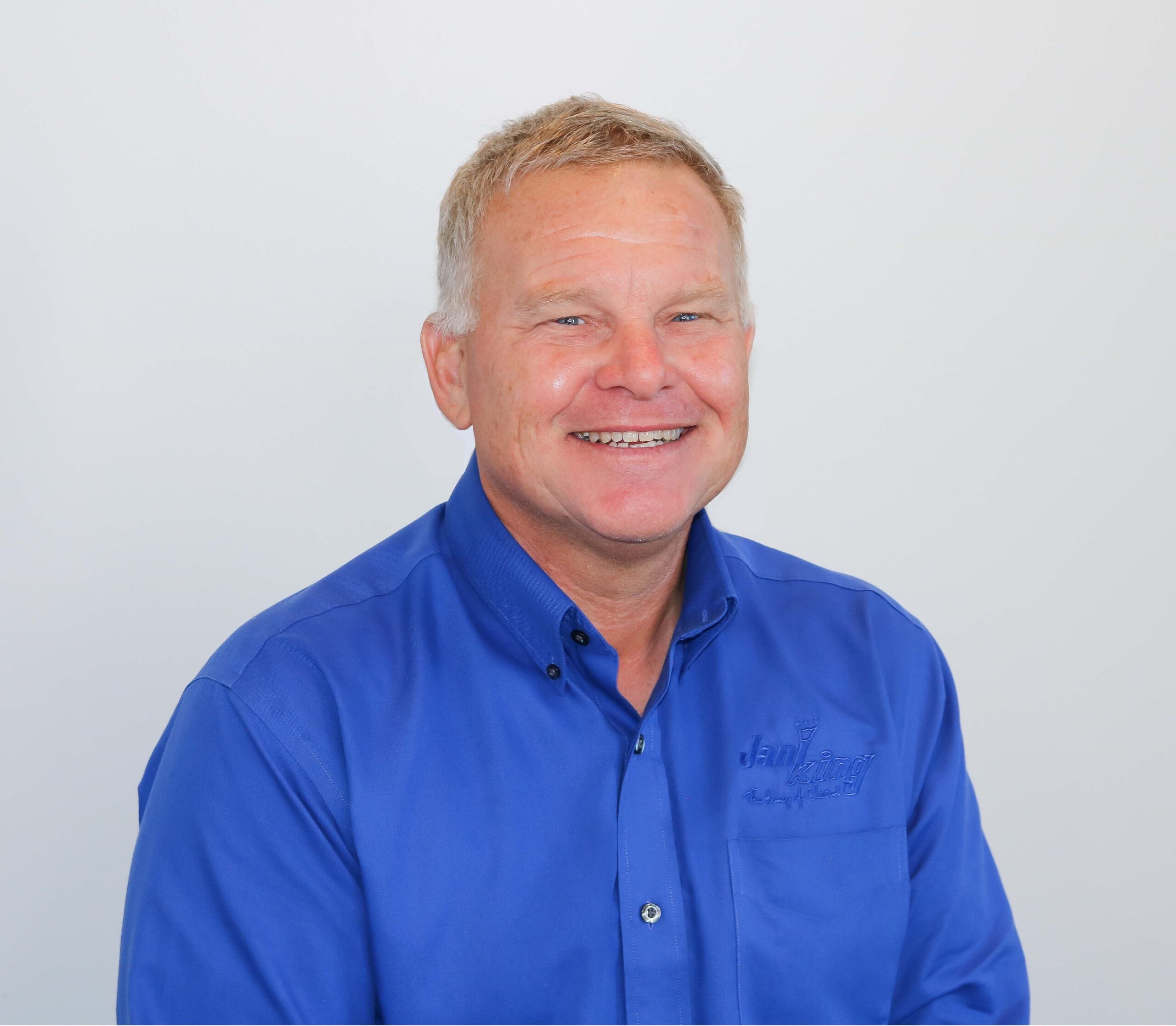 a man in a blue shirt smiles for the camera