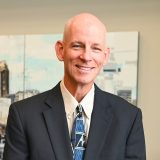 a man in a suit and tie smiling a man in a suit and tie smiling