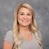 a woman with long blonde hair and a gray shirt a woman with long blonde hair and a gray shirt