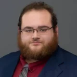 a man with a beard and glasses Timothy Lennox's professional headshot
